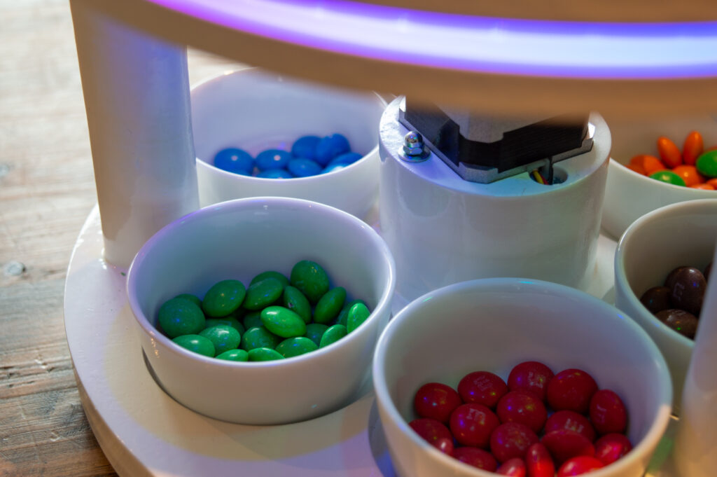 Several bins filled with M&Ms sorted by colour